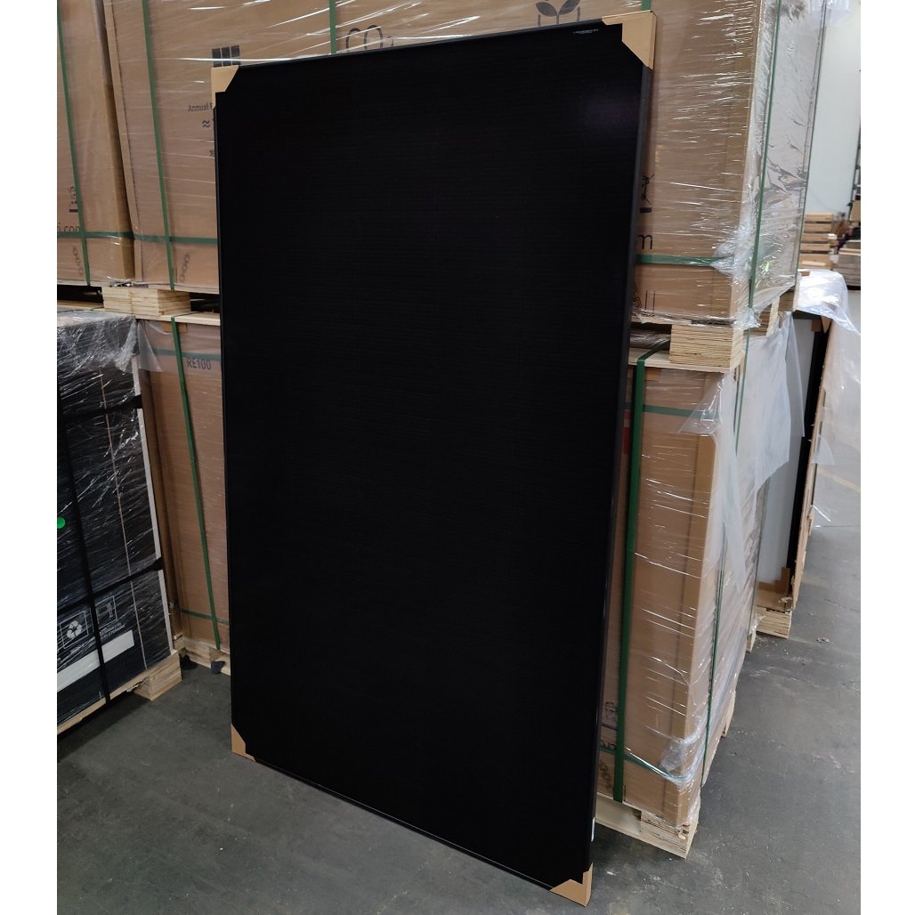 Et 430w all black Hyundai G12 PERC Shingled solcellepanel, der læner sig op ad en palle, så man kan få en idé om størrelsesforholdet