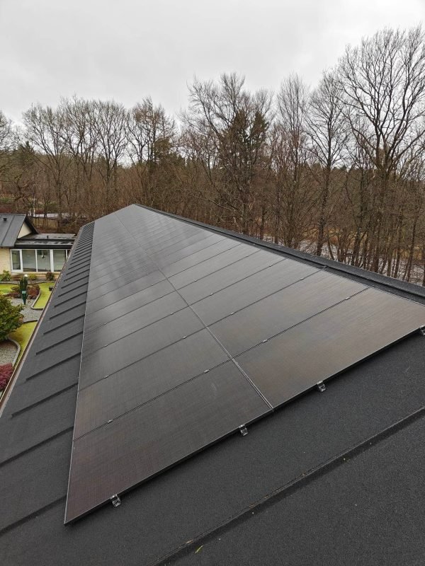 Et skråtag af tagpap med 2 rækker af solcellepaneler installeret